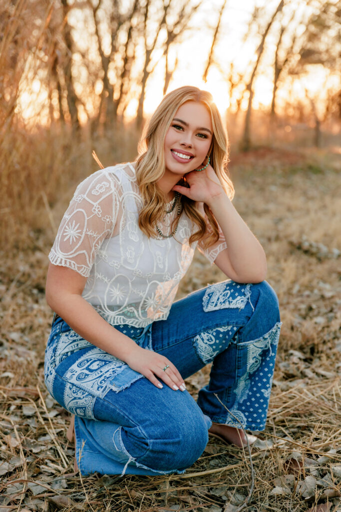 senior photo outfits. Senior posing with white lace top and trendy jeans
