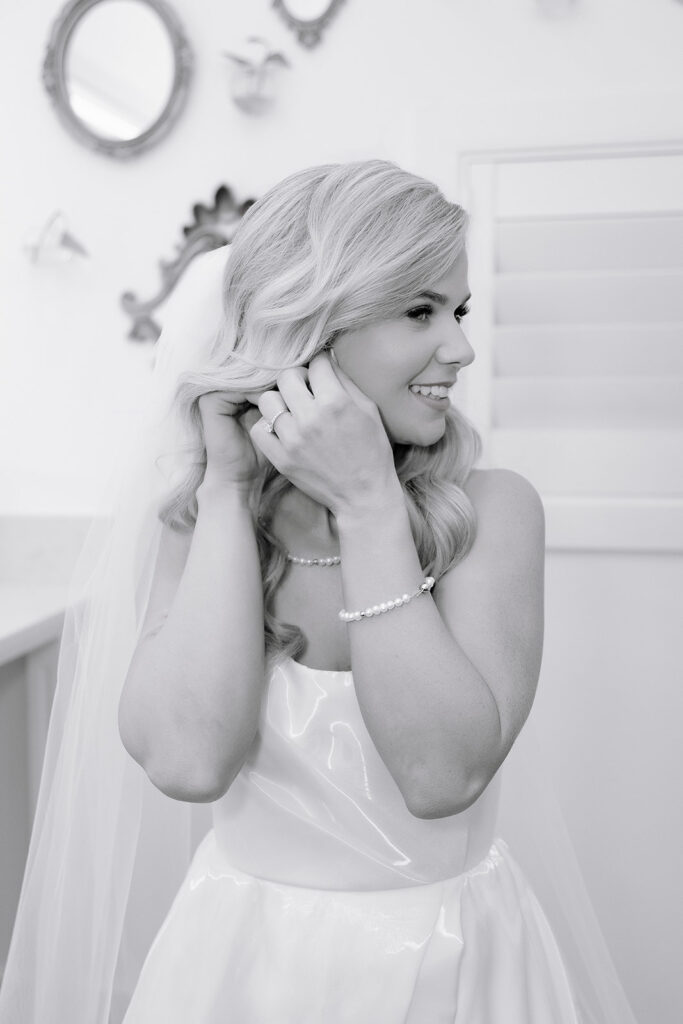 Oklahoma city wedding bride putting on jewelry in a black and white photo