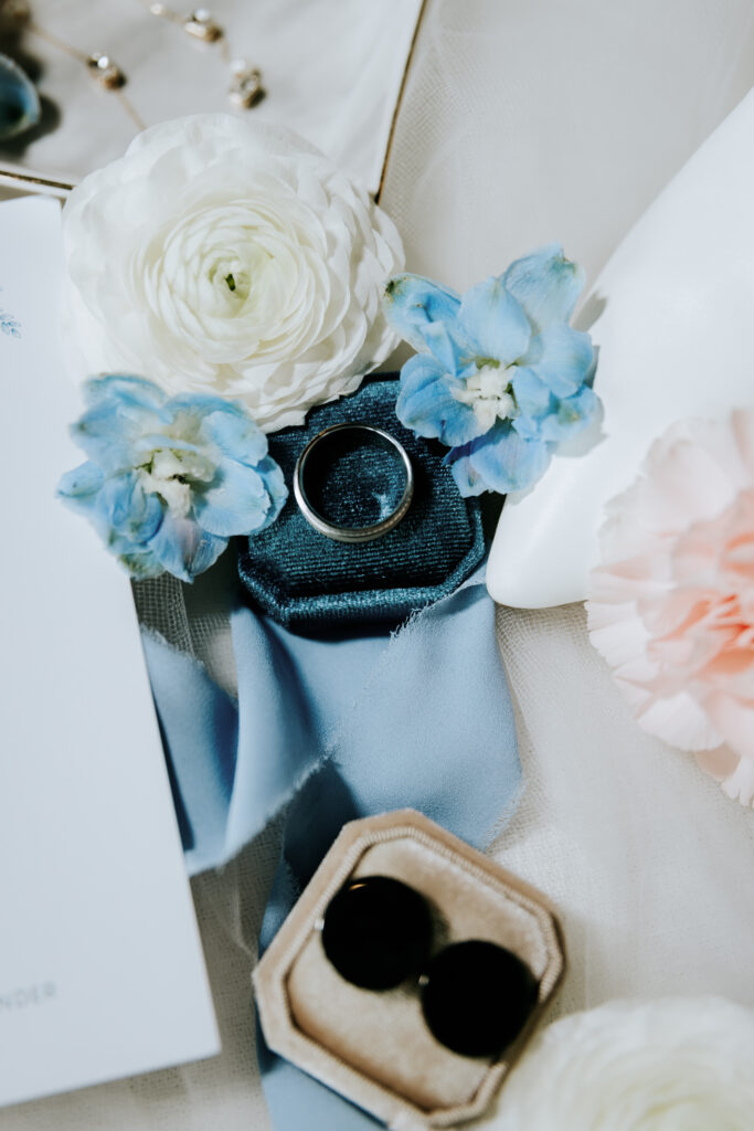 groom lay flat detail shot of cuff links and rings with blue and white elements