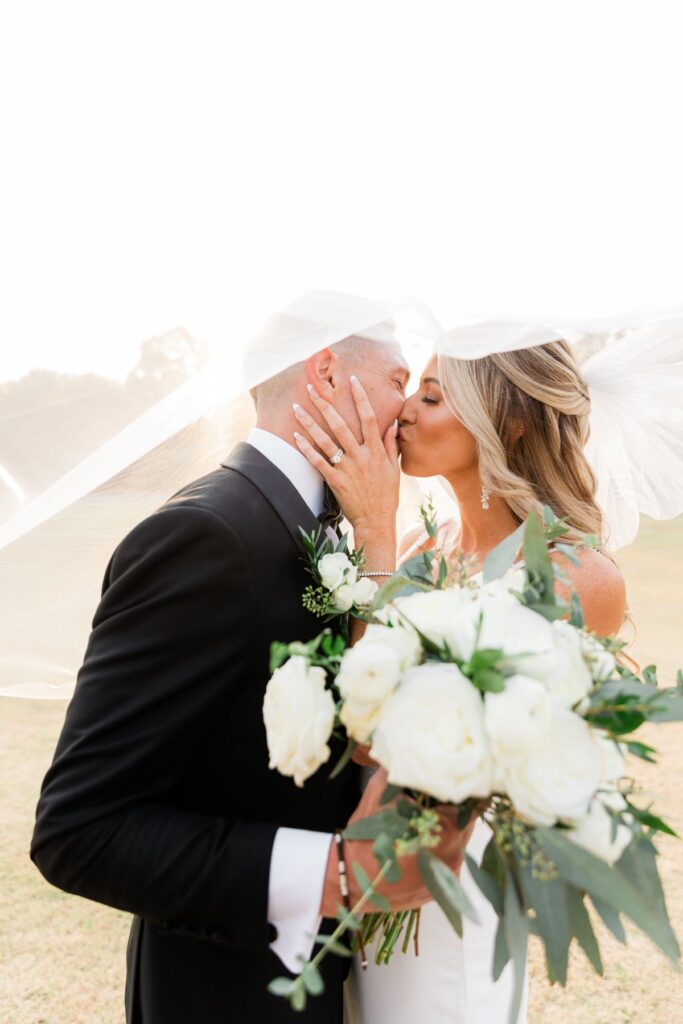 Wedding Day Timeline | Couple with kiss under veil