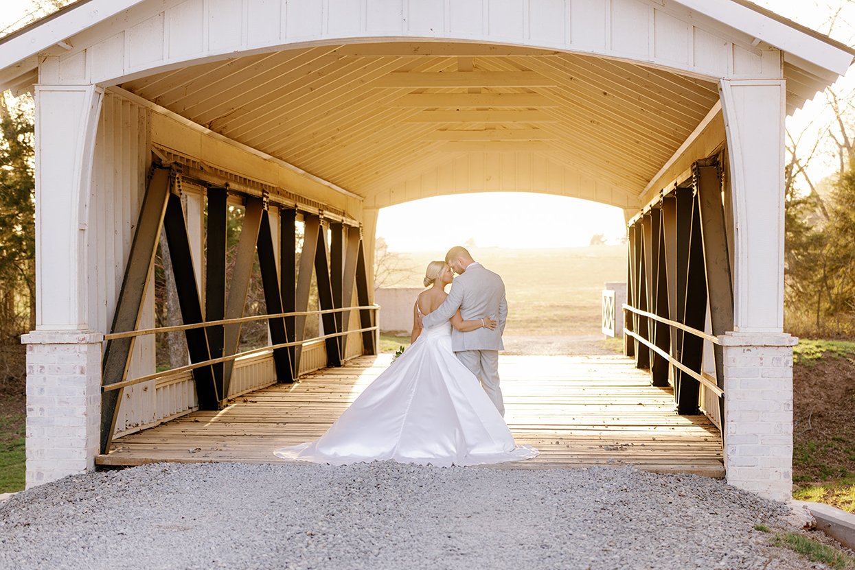 the bride and groom posing under the bridge at the range an oklahoma city wedding venue